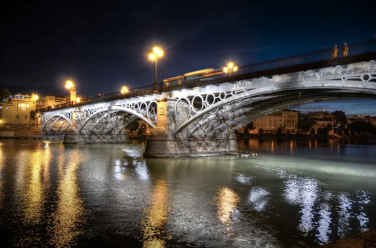 Image of the Triana Bridge illuminated in the middle of the night