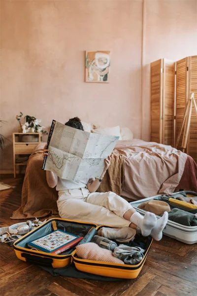 Chica mirando un mapa en su habitación para decidir qué experiencia quiere realizar.